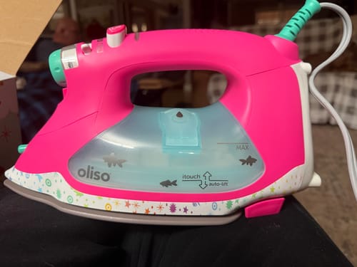 Customer's bright pink Oliso Tula Pink Iron showing its colorful patterned base and goldfish designs on the water tank.