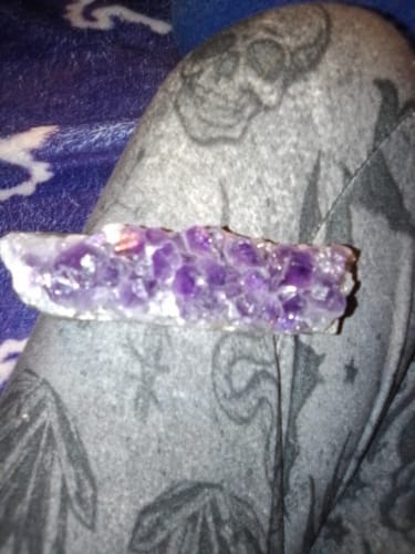 Close-up of a reviewer's long, purple Amethyst Crystal Cluster resting on their lap.