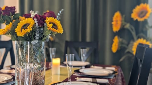 Close-up of a customer's dining table set for the Monarchy Game, featuring a large floral centerpiece.