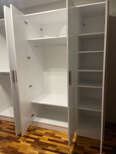 Yorumcunun kurduğu beyaz Rani gardırobun açık kapılarından içindeki raflar ve askı bölümü görünüyor.