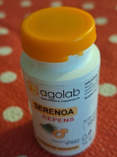 Recensore mostra il flacone bianco dell'integratore Serenoa Repens con tappo arancione.