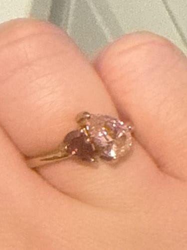 Close-up of a customer wearing the Leesha Birthstone Ring, showing two sparkling stones on a gold band.
