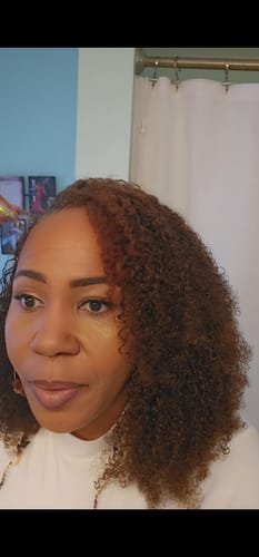 Customer showing her medium brown Kinky Curly Crochet Hair styled with a deep side part.
