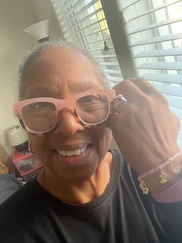 Reviewer smiling while wearing a pink beaded bracelet featuring a gold Snowflake Charm.