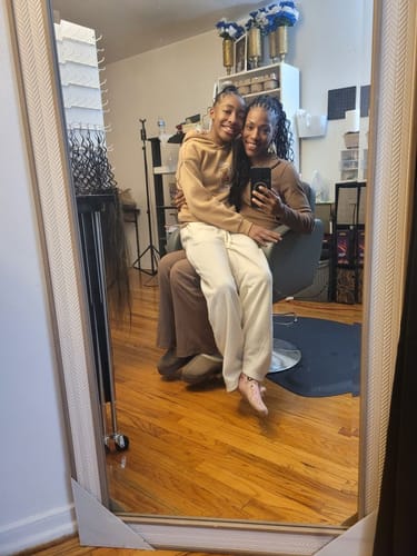 Reviewer with long, wavy Feather Crochet Boho Hair takes a mirror selfie with another person in a salon.