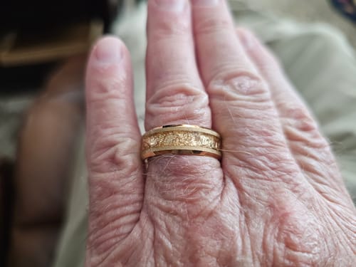 Customer's hand wearing the gold Aureum ring, showing the textured gold foil inlay.