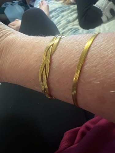 Customer wearing the braided gold Palm Beach Bracelet layered with a second bracelet on their wrist.
