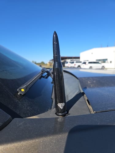 Reviewer's black PREMIUM BULLET ANTENNA installed on a truck, replacing the old factory antenna.