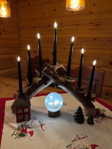 Anmelders belyste Lyslykt LED hytte plassert under en hjemmelaget adventsstake på et bord.