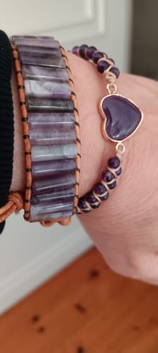 Gros plan du poignet d'un client portant le bracelet Améthyste 'Chakra' avec ses pierres violettes rectangulaires.