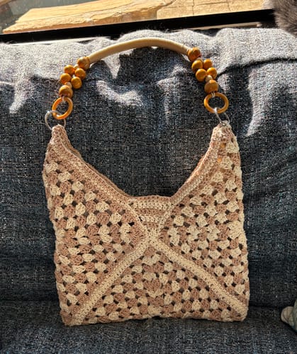 Customer's finished Sunny Holiday shoulder bag in beige and brown crochet, shown with its distinctive wooden beaded handles.