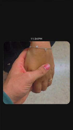 Close-up of a customer wearing the Silver Stunning You Bracelet while holding another person's hand.