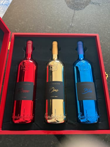 Reviewer's Lamborghini LUXE Red Collection gift set showing three elegant metallic bottles in a red presentation box.