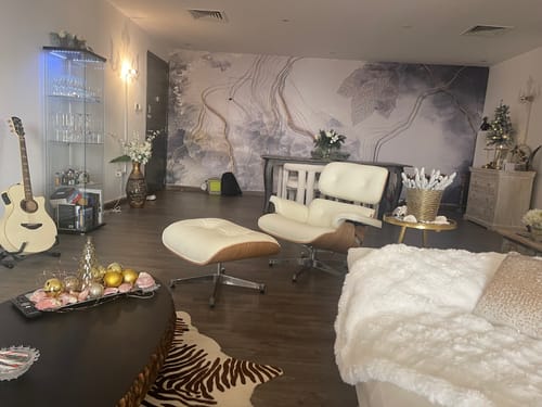 Customer's creamy-white Lounge Chair and Ottoman set up in a stylish living room.