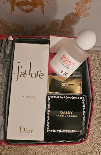 Reviewer shows their perfume collection in a travel case as a comparison for the Petal Symphony fragrance.