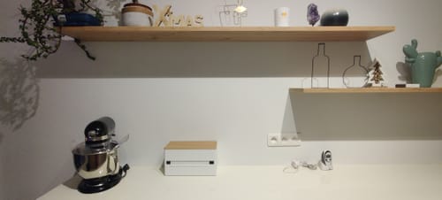 Recensent's witte Yamazaki Keukenrolhouder met houten deksel, op een wit aanrecht geplaatst.