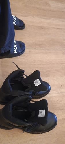 Kundenfoto zeigt Füße in POLIZEI-Sandalen und daneben liegende schwarze Schuhe.