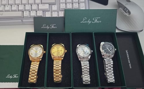 Reviewer's four Lucky Fours Santos watches in open green boxes, showing two gold-toned and two silver-toned watches.
