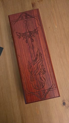 Customer's Flaming Sword dice vault in a beautiful reddish wood, showing the etched sword and flame design on the lid.