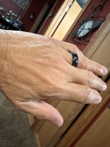 A reviewer's hand wearing the black, hammered Dravus ring to show its fit.