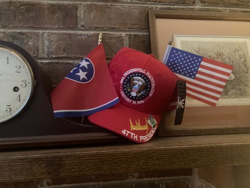 Customer photo of a red cap with small American and Tennessee flags on a shelf.