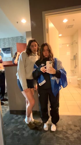 Reviewer taking a mirror selfie with her phone, which has a light pink Lace Pink case.