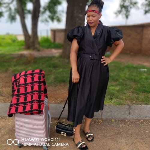 Reviewer standing outdoors wearing the black Elegant Overlap Collar A-line Midi Dress.