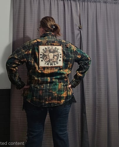 Reviewer showing the back of the hand-dyed Can't Be Tamed flannel, highlighting the custom patch.