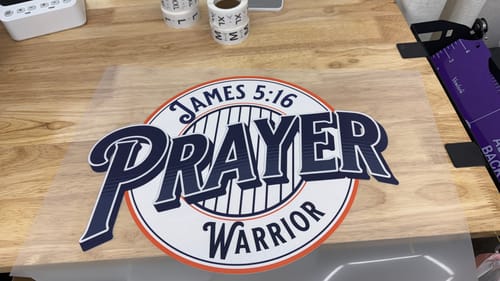 Customer's DTF Transfer Film with a detailed 'Prayer Warrior' graphic printed on it before application.