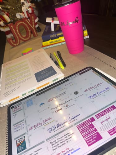 Customer's Digital Planner shown on a tablet with a busy monthly calendar layout, set up on a desk.