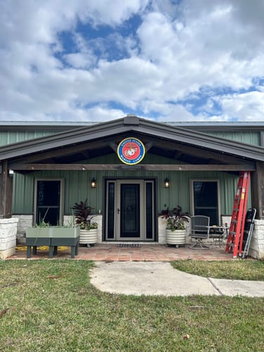 Reviewer's United States Marine Corps Seal wall art mounted on the exterior of their home above the front porch.