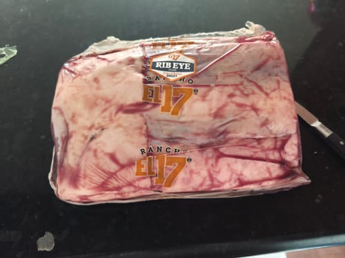 Pieza básica de Rib Eye del cliente, en su empaque al vacío sobre una barra de cocina.