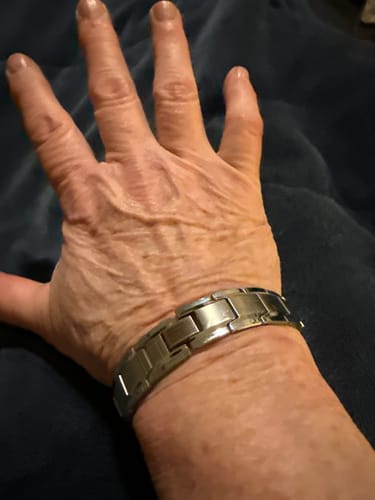 Close-up of a reviewer wearing the Iron Man Titanium Magnetic Bracelet on their wrist.