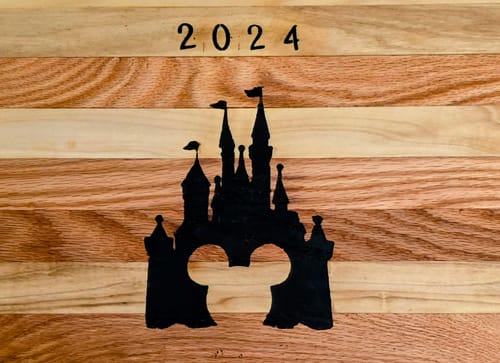 Customer's wooden block with a burned Disney castle silhouette and "2024" created using Scorch Paint.