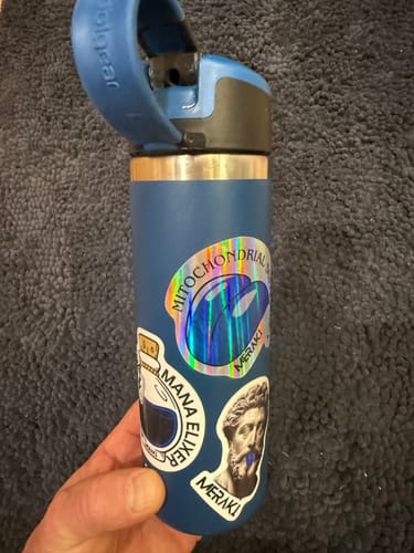 Customer holding a blue water bottle with stickers included with their Meraki Blu Methylene Blue.