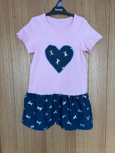 Customer's handmade dress using Foil Unicorns fabric for the skirt and a heart appliqué on the pink top.