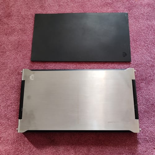 Customer's new CyberPlate with its brushed steel finish and black rollers, displayed next to a black mat.