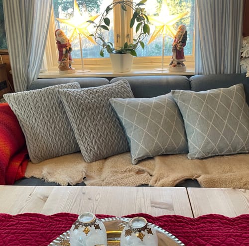 Kundens to flettede velurputetrekk vist på en sofa ved siden av to andre mønstrede puter.