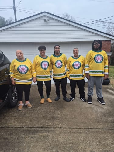 Customer's family posing in their matching yellow Family Christmas Custom Hockey Jerseys outdoors.