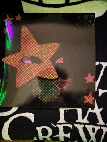 Reviewer's dark photo of their Custom Vinyl Record Cover, featuring a holographic star design on a black background.