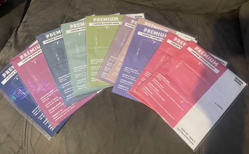 Reviewer's assortment of CUSTOM A5 POCKET PAGES fanned out in their colorful packaging.