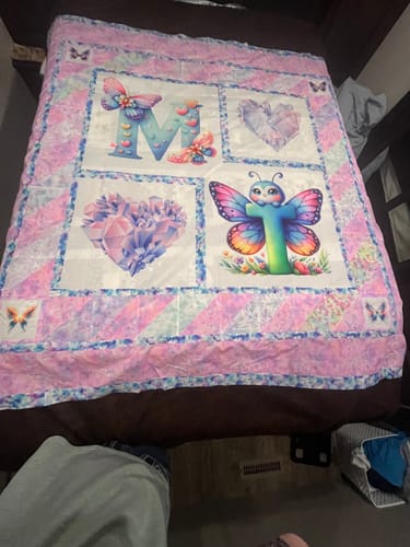Customer's unfinished quilt showing the tie-dye fabric used for the colorful border around a central butterfly-themed panel.