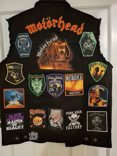 Customer's Wolfsbane - Live Fast, Die Fast patch sewn onto the back of a black vest covered with other band patches.