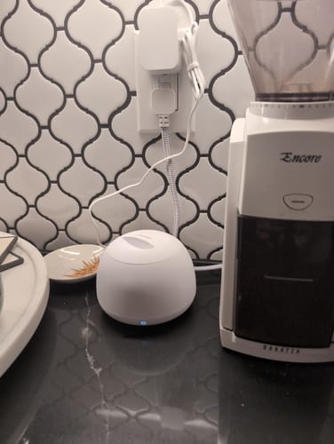 Customer's white Dental Pod Pro on a dark countertop, plugged into a wall outlet.