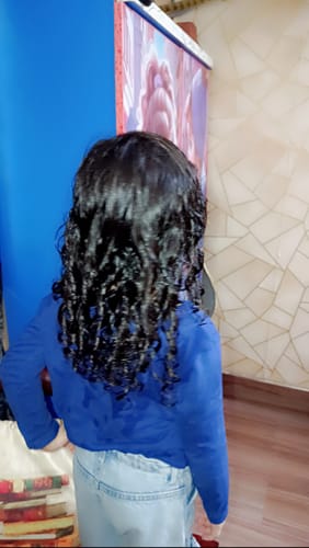 Reviewer's child from behind, showing their shiny, defined curls after using the Curly Kids Bundle.