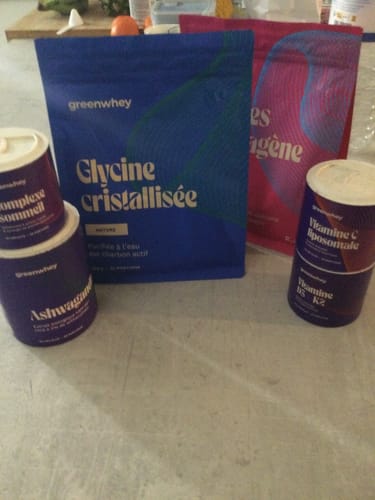 Client montrant son sachet de Glycine cristallisée avec d'autres compléments de la même marque sur une table.