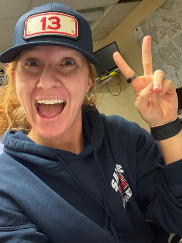 Customer smiling while wearing the dark blue SNAPBACK HOSE HAT with a custom '13' station patch.