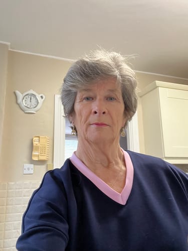 A close-up of a reviewer wearing the navy sweatshirt with pink trim from the Vivien Tracksuit set.