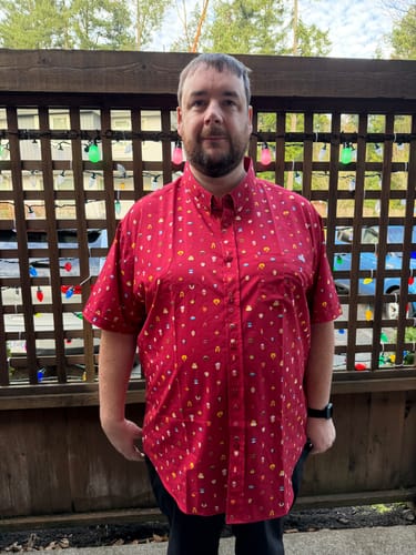 Customer wearing the red 'Lil Muppets' short-sleeve button-down shirt outdoors.