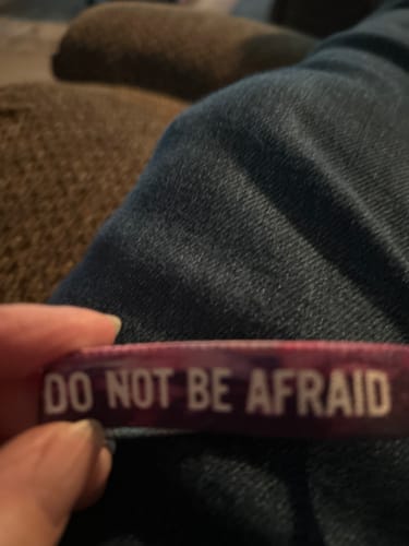 Close-up of a reviewer holding the purple 'Do Not Be Afraid' Bible verse bracelet.